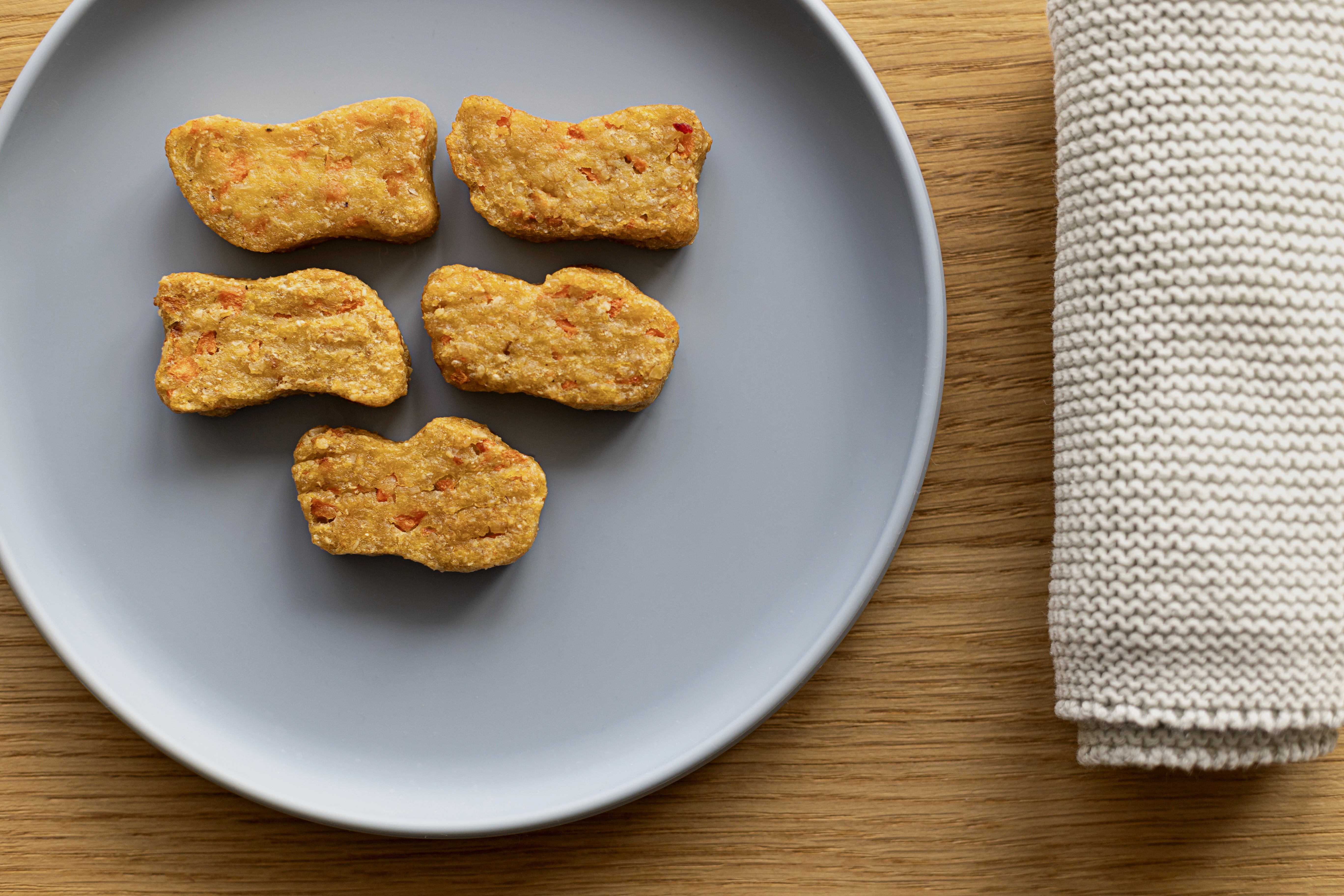 breifreie Gemüse Kartoffel Karotte Nuggets für Babys ab 18 Monaten auf Babyteller angerichtet